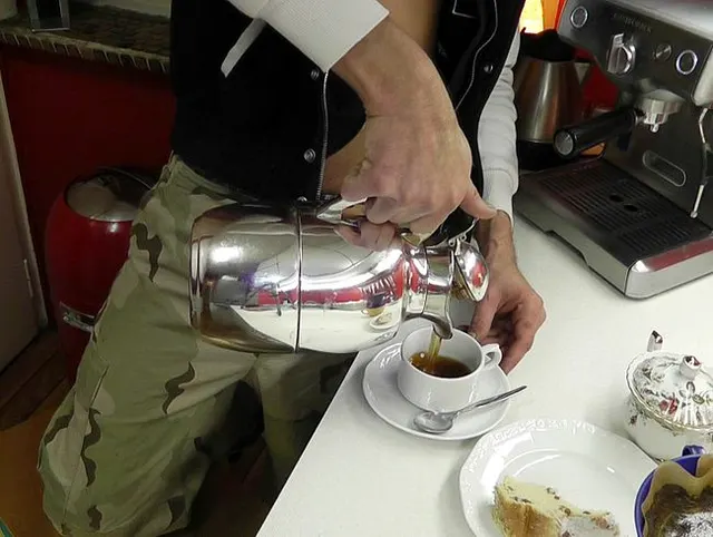 Latino Küchenjunge pisst in die Kaffeekanne voll